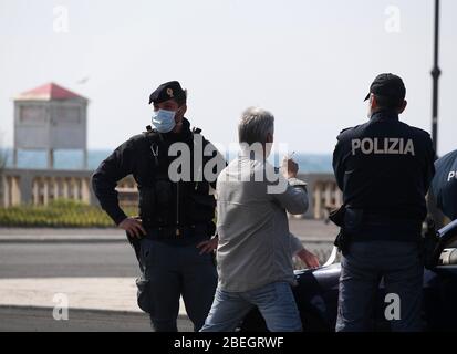 Rome, Italie. 13 avril 2020. Les policiers vérifient un piéton à Ostia, Rome, Italie, le 13 avril 2020. La pandémie COVID-19 a fait état de 20 465 morts en Italie à la suite de la période de lundi, portant le nombre total d'infections, de morts et de reprises à 159 516, selon les dernières données publiées par le Département de la protection civile du pays. Crédit: Augusto Casasoli/Xinhua/Alay Live News Banque D'Images