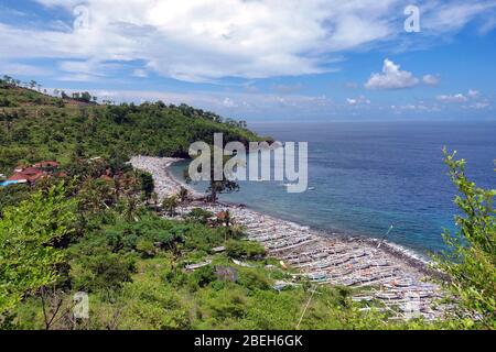 Vue aérienne sur une baie près d'Amed à Bali, Indonésie. Il est plein de bateaux de pêche traditionnels appelés jukung sur la plage de sable noir, partiellement couvert par Banque D'Images