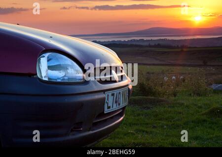 1993 L enregistrement bordeaux berline 3 portes Vauxhall / Opel Corsa voiture au coucher du soleil Banque D'Images
