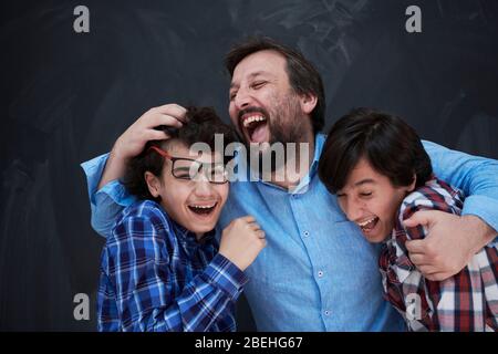 un père heureux embrassant des fils inoubliables moments de joie familiale dans la race mixte de la famille arabe du moyen-orient Banque D'Images