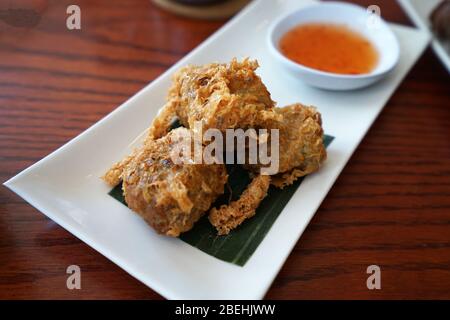 Gros rouleaux de viande de crabe frits sur table en bois Banque D'Images