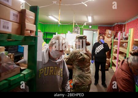 Ellettsville, États-Unis. 13 avril 2020. Un membre de la Garde nationale de l'Indiana appuie les travailleurs bénévoles dans la distribution de nourriture à Pantry 279 pour aider ceux qui souffrent d'insécurité alimentaire pendant le séjour à domicile de COVID-19/Coronavirus.Hoosiers ont été commandés pour voyager seulement pour des besoins essentiels. Crédit: SOPA Images Limited/Alay Live News Banque D'Images