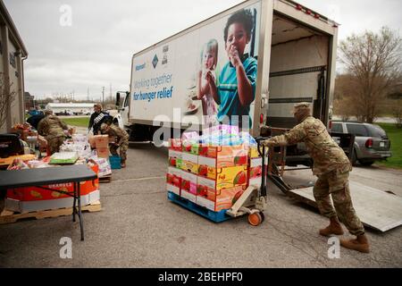 Ellettsville, États-Unis. 13 avril 2020. Les membres de la Garde nationale de l'Indiana soutiennent les travailleurs bénévoles dans la distribution de nourriture à Pantry 279 pour aider ceux qui souffrent d'insécurité alimentaire pendant le séjour à domicile de COVID-19/Coronavirus.Hoosiers ont été commandés pour voyager uniquement pour des besoins essentiels. Crédit: SOPA Images Limited/Alay Live News Banque D'Images