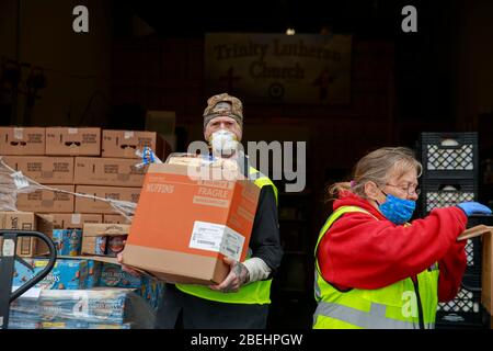 Ellettsville, États-Unis. 13 avril 2020. Un volontaire transporte des aliments à un client tout en aidant à distribuer des aliments à Pantry 279 pour aider ceux qui souffrent d'insécurité alimentaire pendant le séjour à domicile de COVID-19/Coronavirus.Hoosiers ont été commandés pour voyager uniquement pour des besoins essentiels. Crédit: SOPA Images Limited/Alay Live News Banque D'Images