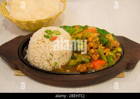 Riz avec viande et légumes sauté. Repas de cuisine asiatique servi avec du pain plat Banque D'Images