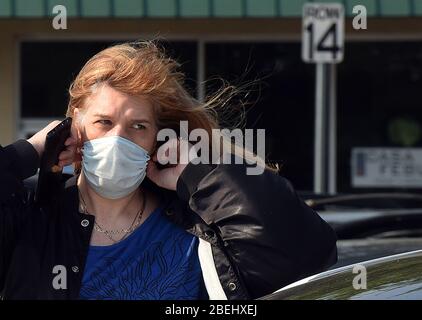 Kissimmee, États-Unis. 13 avril 2020. 13 avril 2020 - Kissimmee, Floride, États-Unis - une femme porte un masque à l'extérieur d'un magasin à Kissimmee, en Floride, le 13 avril 2020, le premier jour où les responsables locaux du comté d'Osceola, La Floride, près d'Orlando, a rendu obligatoire le port de revêtements de visage dans un effort pour freiner la propagation de la pandémie COVID-19. Crédit: Paul Hennessy/Alay Live News Banque D'Images