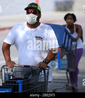 Kissimmee, États-Unis. 13 avril 2020. Les gens portent des masques à l'extérieur d'un magasin le premier jour où les responsables locaux du comté d'Osceola, en Floride, près d'Orlando, ont rendu obligatoire le port de revêtements de visage dans un effort pour freiner la propagation de la pandémie COVID-19. Crédit: SOPA Images Limited/Alay Live News Banque D'Images