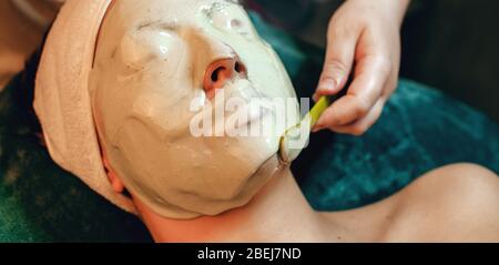 Masque d'alginate appliqué sur le visage de la femme caucasienne au salon de spa tout en couché Banque D'Images