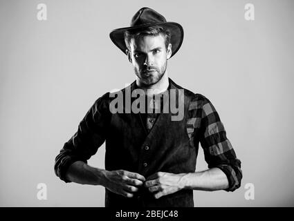 Port de Cowboy hat. La vie dans l'Ouest. Homme cowboy non rasé beige background. Guy non rasé en chapeau de cowboy. Beau macho barbu. American Cowboy. Norme de beauté. Exemple d'une véritable masculinité. Banque D'Images