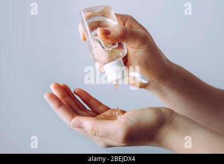 Vue rapprochée de la femme en utilisant un petit désinfectant pour les mains antibactérien portable sur les mains. Banque D'Images