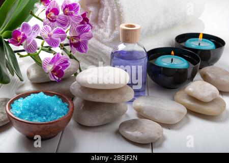 composition du traitement spa. Bougies dans des bols avec de l'eau, des sels de bain et des fleurs d'orchidées. Banque D'Images