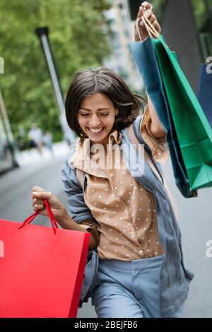 Happy woman with shopping bags bénéficiant dans le shopping. Le consumérisme, shopping, style de concept Banque D'Images