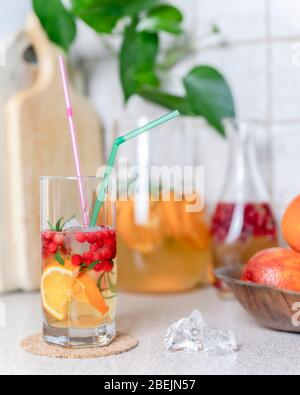 Limonade maison avec citron, orange et canneberge avec glace dans le verre et pichet sur la table. Boisson rafraîchissante froide d'été. Banque D'Images