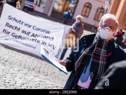 Schwerin, Allemagne. 14 avril 2020. Thomas Lenz, Secrétaire d'Etat au Ministère de l'intérieur de l'Etat de Mecklembourg-Poméranie occidentale, portant un masque facial, accepte la collecte de 1 500 signatures de membres de l'Initiative Pro Bleiberecht (Initiative pour le droit de séjour). La pétition demande le droit de rester dans les logements des demandeurs d'asile. Le tribunal administratif avait précédemment levé une interdiction de réunion. Crédit: Jens Büttner/dpa-Zentralbild/dpa/Alay Live News Banque D'Images