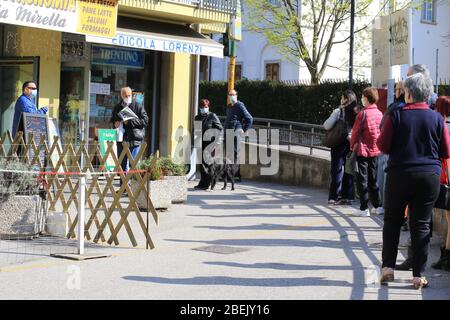 Pergine Valsugana, Italie. 11 avril 2020. Pergine Valsugana, Italie. 11 avril 2020 : files d'attente de personnages masqués. Un verrouillage radical est en place en Italie pour tenter de ralentir la propagation de l'épidémie de coronavirus. Pour la plupart des gens, le nouveau coronavirus ne cause que des symptômes légers ou modérés. (Photo de Pierre Teyssot/ESPA-Images) crédit: Agence européenne de photo sportive/Alay Live News Banque D'Images