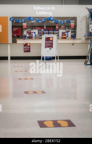 Redhill, Surrey, Royaume-Uni - 10 avril 2020 - les marquages sur un supermarché aident à maintenir des distances sociales pour arrêter la propagation du coronovirus Banque D'Images