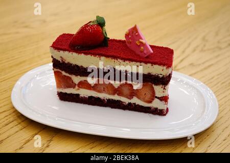 sur la table, une tranche de gâteau de velours rouge. servi avec du chocolat au rubis et des fraises. une tranche de tarte de gros plan Banque D'Images