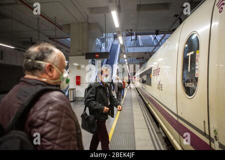 Gérone, Espagne. 14 avril 2020. Les passagers embarquent dans un tramway tout en portant des masques de protection contre la propagation du Coronavirus (COVID-19) à la gare de Gérone. Le gouvernement espagnol rétablit les emplois non essentiels en Catalogne après 31 jours de confinement. Plus de 1 700 000 personnes reviennent au travail. Les agents de protection civile et de police distribuent des masques aux gares ferroviaire et routière pour empêcher l'augmentation de la propagation de Covid-19. Crédit: SOPA Images Limited/Alay Live News Banque D'Images