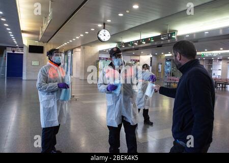 Gérone, Espagne. 14 avril 2020. Les membres espagnols de la protection civile distribuent un masque facial à un homme comme mesure préventive contre la propagation du Coronavirus (COVID-19) à la gare de Gérone. Le gouvernement espagnol rétablit les emplois non essentiels en Catalogne après 31 jours de confinement. Plus de 1 700 000 personnes reviennent au travail. Les agents de protection civile et de police distribuent des masques aux gares ferroviaire et routière pour empêcher l'augmentation de la propagation de Covid-19. Crédit: SOPA Images Limited/Alay Live News Banque D'Images