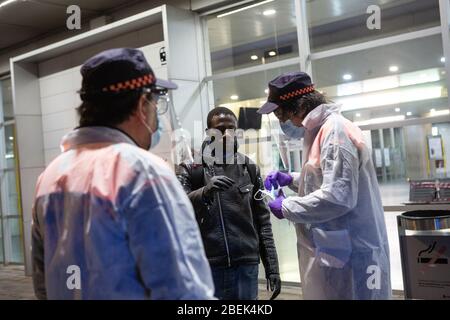 Gérone, Espagne. 14 avril 2020. Les membres espagnols de la protection civile distribuent un masque facial à un homme comme mesure préventive contre la propagation du Coronavirus (COVID-19) à la gare de Gérone. Le gouvernement espagnol rétablit les emplois non essentiels en Catalogne après 31 jours de confinement. Plus de 1 700 000 personnes reviennent au travail. Les agents de protection civile et de police distribuent des masques aux gares ferroviaire et routière pour empêcher l'augmentation de la propagation de Covid-19. Crédit: SOPA Images Limited/Alay Live News Banque D'Images