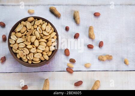 Arachides pleines gardées dans un bol en bois. Banque D'Images