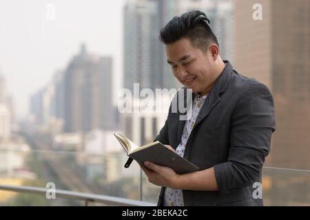 Un bon livre de lecture pour homme d'affaires asiatique en surpoids Banque D'Images