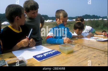 1995 Tuzla, Bosnie - enfants réfugiés sans abri au camp de réfugiés temporaires de l'aérodrome de Tuzla pour les musulmans bosniaques qui fuient le massacre de Srebrenica pendant la guerre de Bosnie, photographiés à l'aide de matériel didactique mis en place par l'UNICEF Banque D'Images