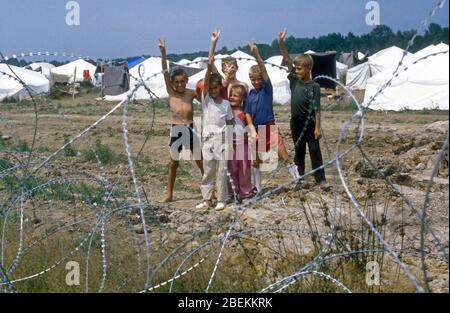 1995 Tuzla, Bosnie - les enfants réfugiés sans abri saluent la victoire au camp de réfugiés temporaire de l'ONU de Tuzla pour les musulmans bosniaques qui fuient le massacre de Srebrenica pendant la guerre de Bosnie Banque D'Images