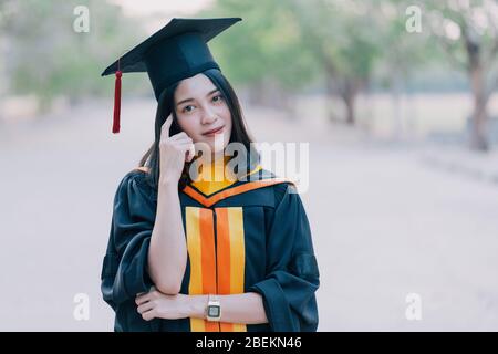 Les jeunes femmes asiatiques de charme célèbrent son diplôme après avoir obtenu un certificat de diplôme le jour du début. Banque D'Images