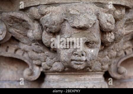 le détail de l'ancienne statue en pierre placée à la porte, ressemble presque à un chérubin Banque D'Images