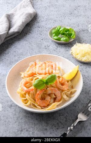 Fettuccine de pâtes italiennes avec fruits de mer, crevettes sur table grise. Prise de vue verticale. Gros plan. Banque D'Images