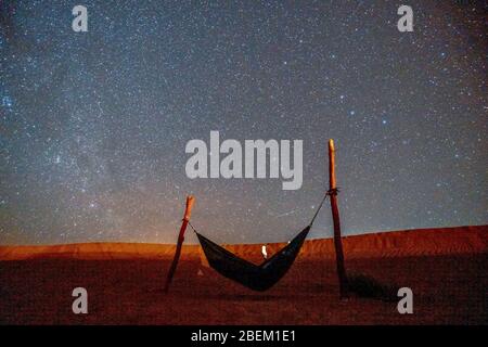 Hamac vert solitaire à côté des dunes sur le désert du Sahara avec un ciel étoilé au-dessus, Maroc Banque D'Images