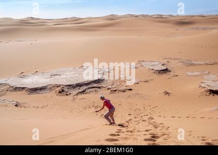 Femme en sable sur le désert du Sahara dans la dune, au Maroc, en Afrique Banque D'Images