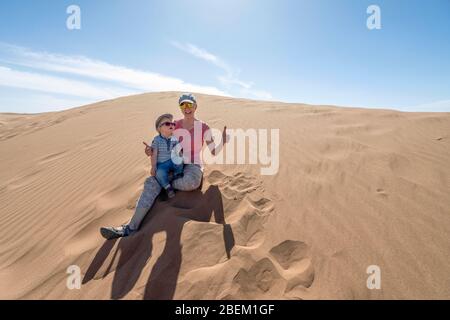 Mère et son fils de 2 ans, assis sur des dunes de sable du Sahara, Maroc, Afrique Banque D'Images