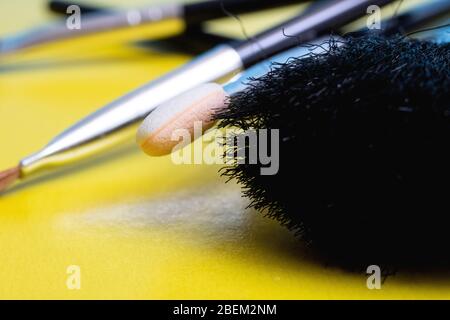 Pinceaux de maquillage sur fond jaune closeup Banque D'Images