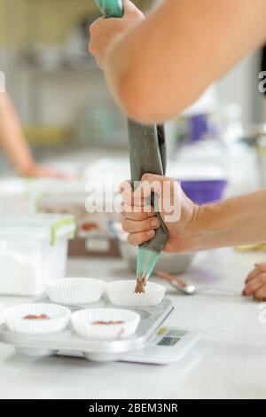 Femme chef pâtissière professionnel pâte à tartiner la pâte au chocolat dans le plat de cuisson. Banque D'Images