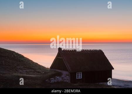 Cabane de pêche au lever du soleil en été le long de la côte de la mer Baltique à Havaeng / Haväng, Österlen / Oesterlen, Skane / Scania, Suède Banque D'Images