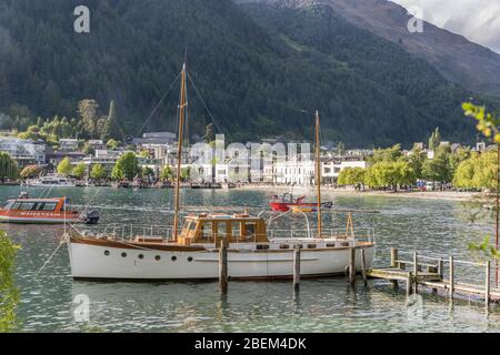 QUEENSTOWN, NOUVELLE-ZÉLANDE - 19 novembre 2019: Paysage urbain avec bateau vintage amarré dans la baie touristique de la ville, tourné dans la lumière de printemps vive le 19 novembre 2019 Banque D'Images