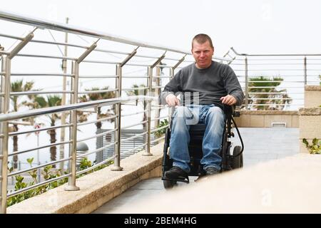 L'homme en fauteuil roulant est assis près de la rampe Banque D'Images