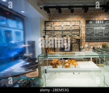 Hissine, employée de Mie Amour dans le 6ème Arrondissement, pose derrière le comptoir lors de son changement à Paris, France, le 10 avril 2020. Comme élément de base de la culture française, de nombreuses boulangeries sont restées ouvertes à Paris pendant la fermeture du Covid-19. Ainsi, des boulangers et des employés ont été jetés sur les lignes de front de la pandémie, portant souvent des masques de visage et travaillant derrière des comptoirs protégés par un emballage en plastique ou du plexiglass pour continuer à servir les gens et maintenir un semblant de normalité. (Photo de Daniel Brown/Sipa USA) Banque D'Images