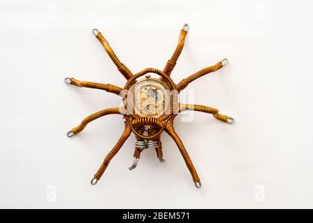 Araignée métallique avec horloge intégrée sur fond blanc, style stéampunk, gros plan Banque D'Images