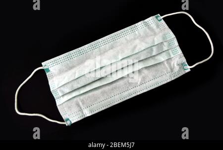 Masque médical, proximité d'un masque chirurgical sur fond sombre, protection antivirus en cas de pandémie Banque D'Images