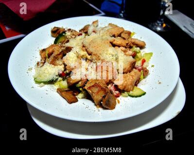 Servir de salade saine avec des légumes, des morceaux de poulet et arrosé de parmesan, un délicieux plat parfait pour les régimes alimentaires faits avec de l'ingrédient organique Banque D'Images