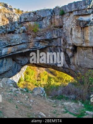 Paysage avec pont de roche naturel formé par une grotte effondrée, connue sous le nom de Pont de Dieu ou 'Podul lui Dumnezeu' à Ponoarele, Mehedinti, Roumanie Banque D'Images