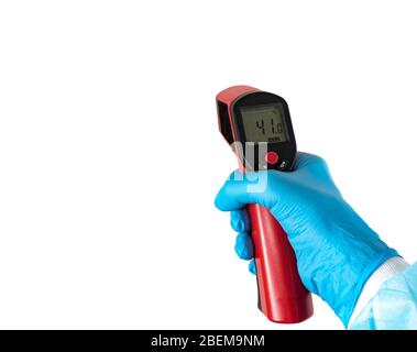 La main du médecin dans un gant de protection contient un thermomètre infrarouge et mesure la température du patient. Mesure à distance de la forte fièvre FO Banque D'Images