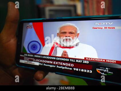 Kolkata, Inde. 14 avril 2020. Les gens font le discours de Narendra Modi sur leur mobile à Kolkata, en Inde, le 14 avril 2020. Le verrouillage du Covid-19 en Inde a été prolongé jusqu'au 3 mai, a déclaré le Premier ministre Narendra Modi dans une allocution devant la nation. Le verrouillage initial de 21 jours devait se terminer mardi. Modi a expliqué que le maintien, ainsi que d'autres mesures de distanciation sociale, ont profité au pays malgré les coûts économiques encourus. (Photo de Biswarup Ganguly/Pacific Press/Sipa USA) crédit: SIPA USA/Alay Live News Banque D'Images