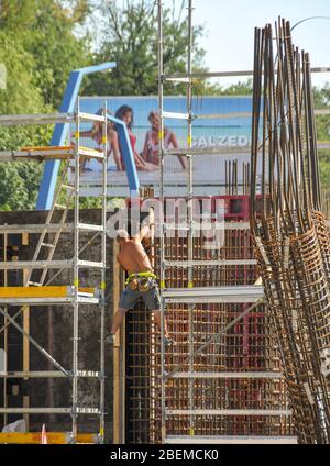 PRAGUE, RÉPUBLIQUE TCHÈQUE - AOÛT 2018: Ouvrier de la construction qui assemble des tiges en acier pour des piliers de soutien en béton armé sur un chantier Banque D'Images