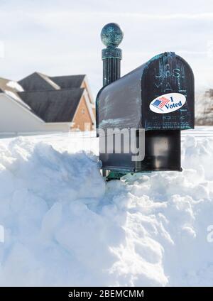 Boîte aux lettres en métal pour les maisons rurales enfouies dans la neige profonde avec j'ai voté autocollant comme concept de vote par courrier ou bulletin de vote absent Banque D'Images