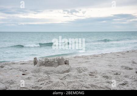 Un château de sable sur la plage avec des vagues douces, une scène sereine pour des vacances en famille en Floride / vacances dans la nature. Banque D'Images