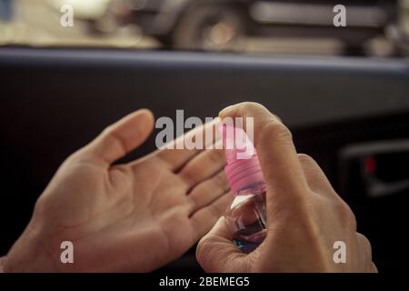 Femmes se laver les mains avec de l'alcool antibactérien aseptisant dans la voiture. Prévenir la propagation des germes et des bactéries et éviter les infections du virus corona. Concept d'hygiène. Banque D'Images